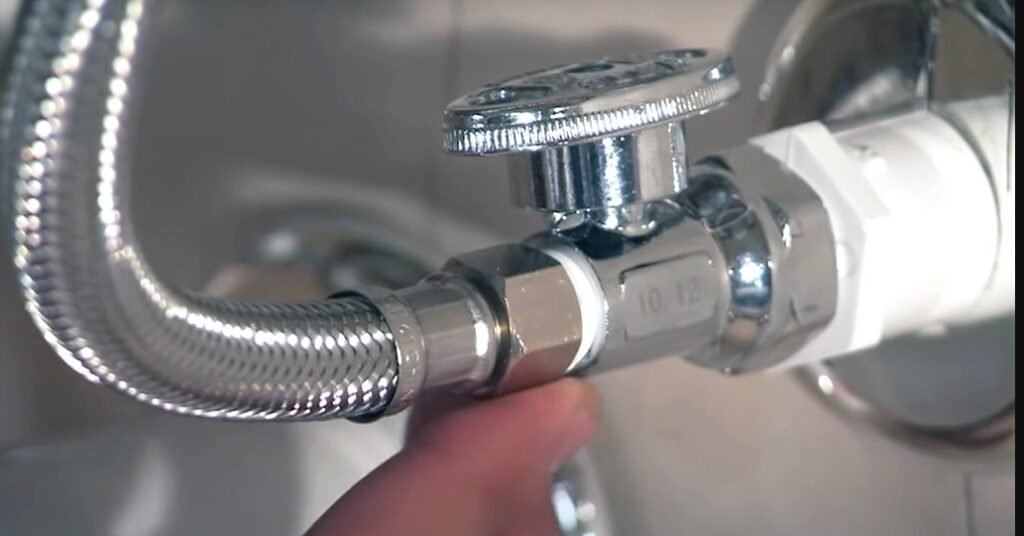 Person fixing faucet with hose.