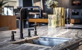 Kitchen featuring a marble countertop, black appliances, and advanced faucet technology.